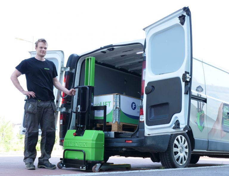 A man stands in front of an InnoLIFT and a white van with it's back doors open.