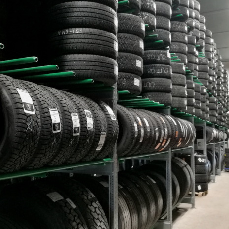 Green tire racks filled with tires horizontally and vertically.