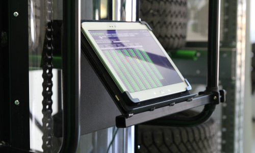 A tablet on a tire stacker tablet holder showing a tire management program.