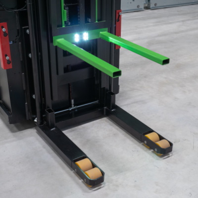 A closeup of two green forks on a machine with a light in between.