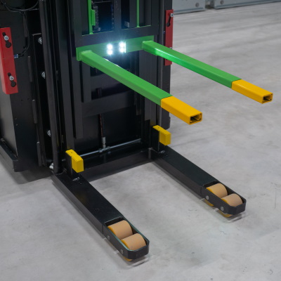 Two green forks on a stacker with yellow extensions on them.