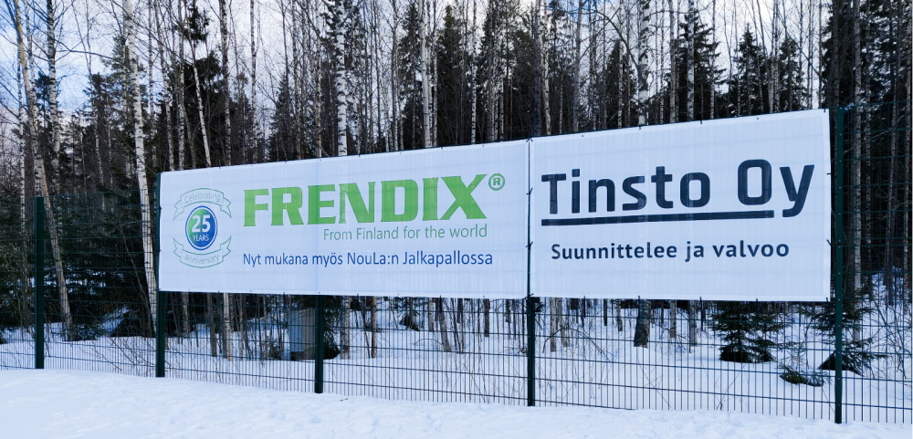 A white banner attaached to a fence with the text: Frendix From Finland to the World.