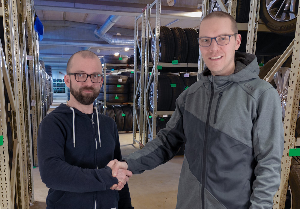Frendixs Markku Hakarinne and Vitec FuturSofts Ilkka Karvonen shake hands in a tire warehouse.